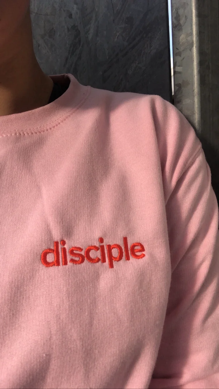 Pink sweatshirt with the embroidered Disciple wordmark